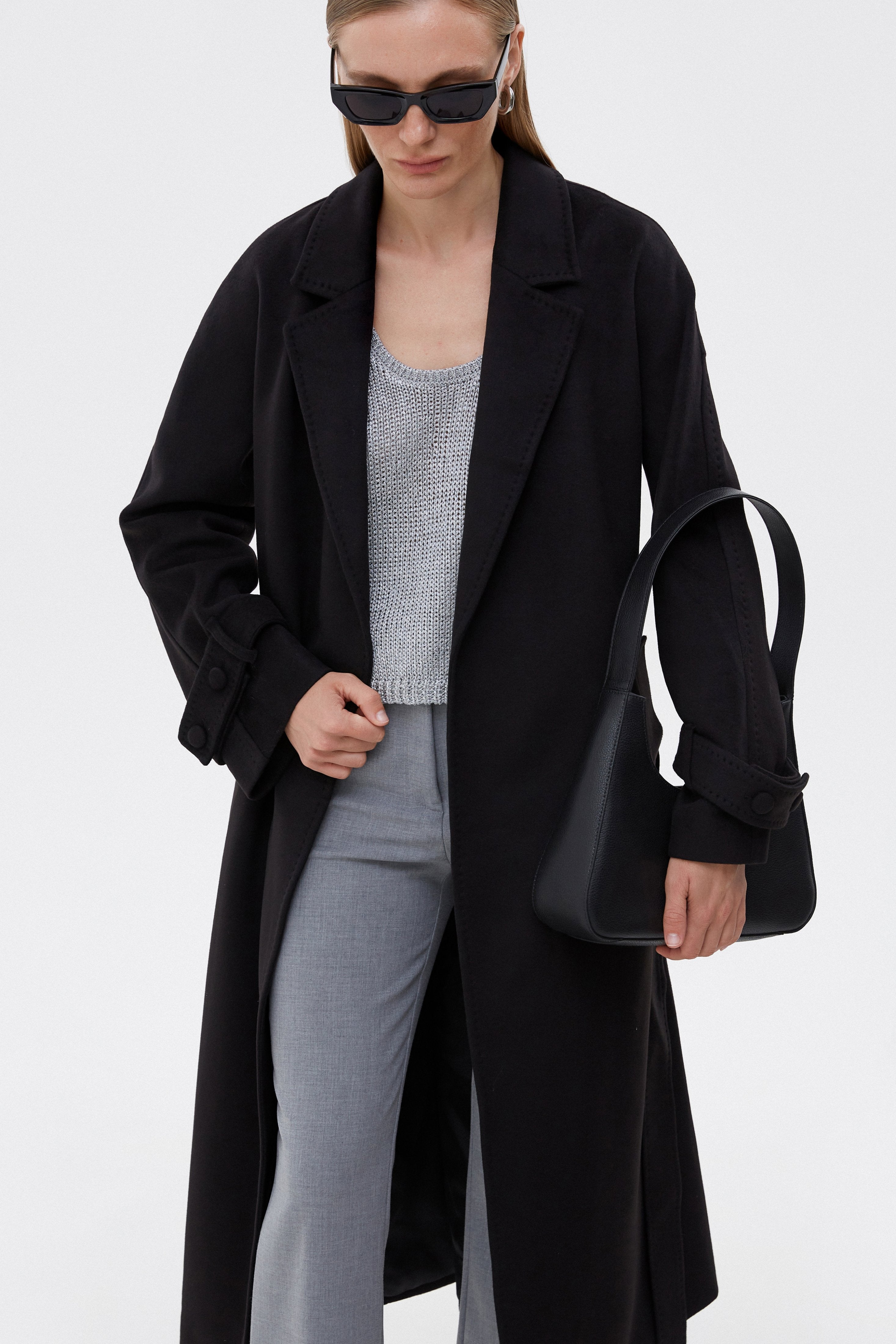 Frontalansicht des langen schwarzen Damen-Mantels im Loose Fit mit Bindegürtel
