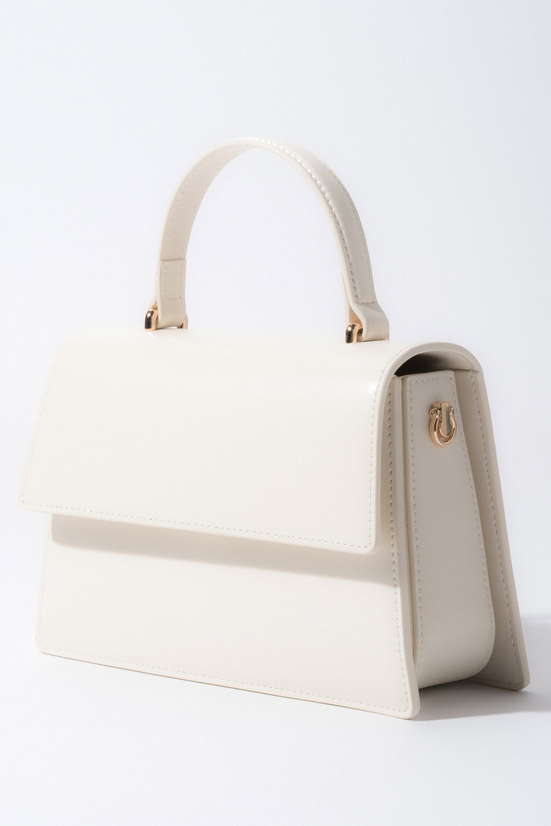 Frontalansicht der milchbeigen Damen-Henkeltasche aus Leder in Kofferchen-Form.