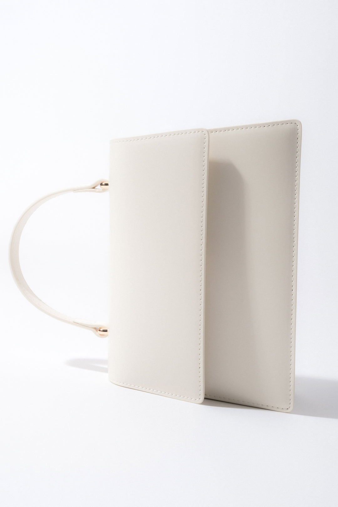 Die milchbeige Leder-Henkeltasche als stilvolles Accessoire.