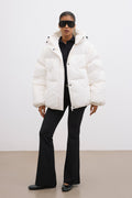 Frontalansicht der milchbeigen Damen-Oversize-Jacke mit Kapuze, kombiniert mit schwarzer Hose im urbanen Look 