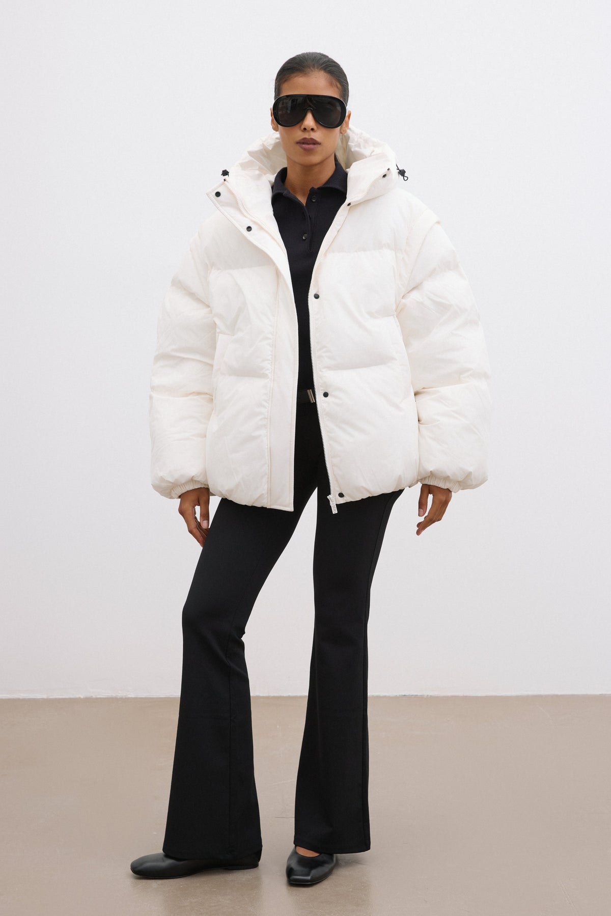 Frontalansicht der milchbeigen Damen-Oversize-Jacke mit Kapuze, kombiniert mit schwarzer Hose im urbanen Look 