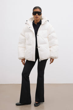 Frontalansicht der milchbeigen Damen-Oversize-Jacke mit Kapuze, kombiniert mit schwarzer Hose im urbanen Look 