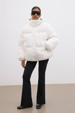 Ganzkörperansicht des Models in der milchbeigen Oversize-Winterjacke von vorne 