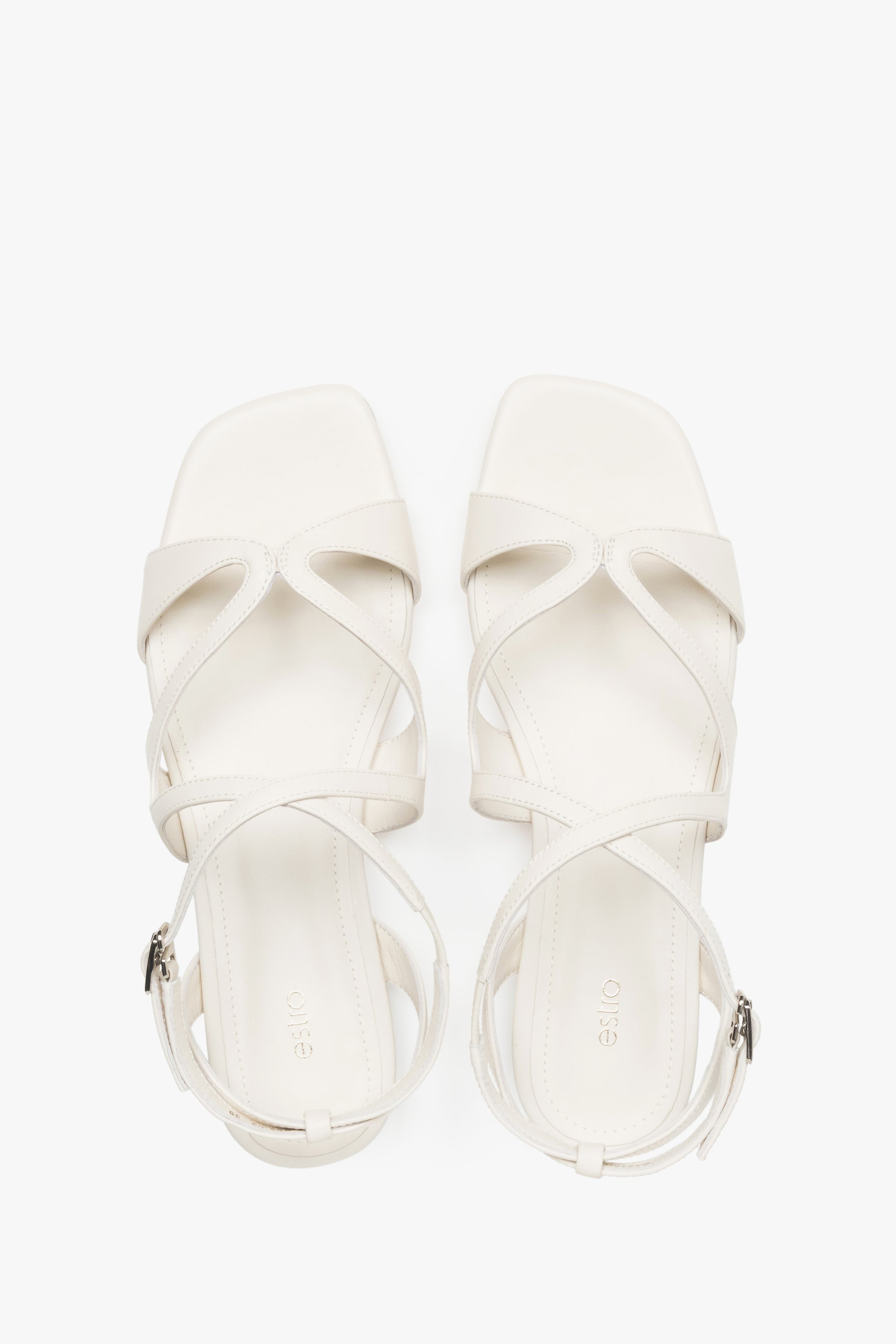 Draufsicht auf das Paar milchbeiger Damen-Sandalen mit Schnallenverschluss.