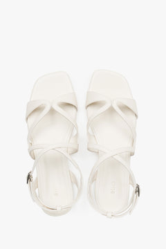 Draufsicht auf das Paar milchbeiger Damen-Sandalen mit Schnallenverschluss.