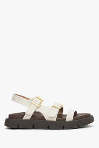 Milchbeige Damen-Sandale aus echtem Leder in seitlicher Ansicht mit goldfarbener Schnalle
