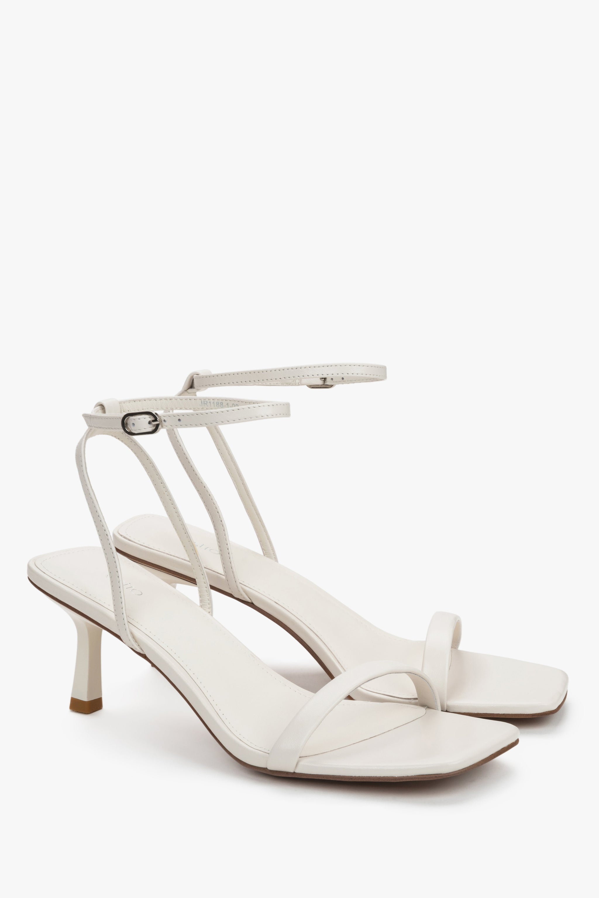 Milchbeige Damen-Sandaletten aus Leder in schräger Vorderansicht mit feinen Riemen