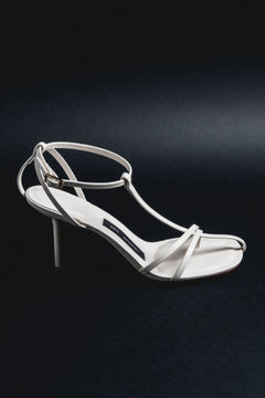 Milchbeige Damen-Sandalette aus Echtleder in schräger Ansicht auf schwarzem Hintergrund