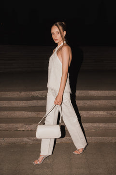 Dynamische Lifestyle-Aufnahme des Models auf einer abendlichen Steintreppe mit der Messenger-Bag