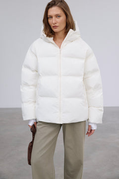 Frontalansicht der milchbeigen Damen-Winterjacke im Loose-Fit, halboffen getragen über einem lässigen Outfit 