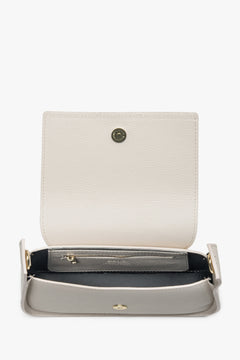 Geöffnete milchbeige Ledertasche, die das luxuriöse Echtleder-Innenfutter und den sicheren Reißverschluss zeigt