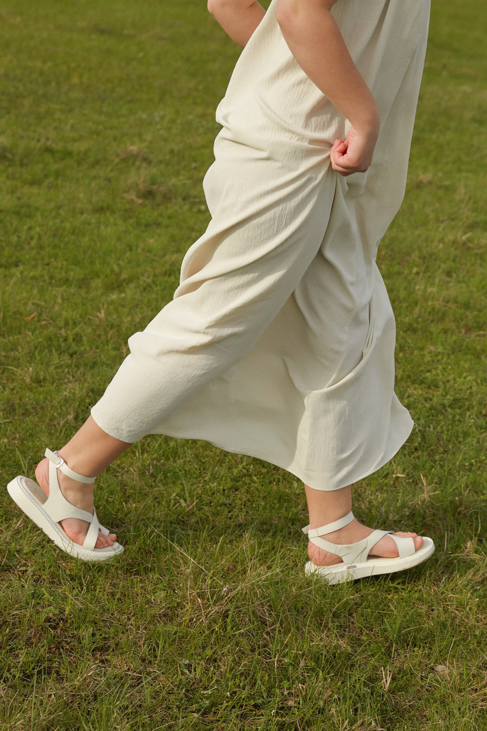 Lifestyle-Ansicht der milchweißen Damen-Sandalen mit Plateausohle in Bewegung.