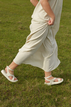 Lifestyle-Ansicht der milchweißen Damen-Sandalen mit Plateausohle in Bewegung.