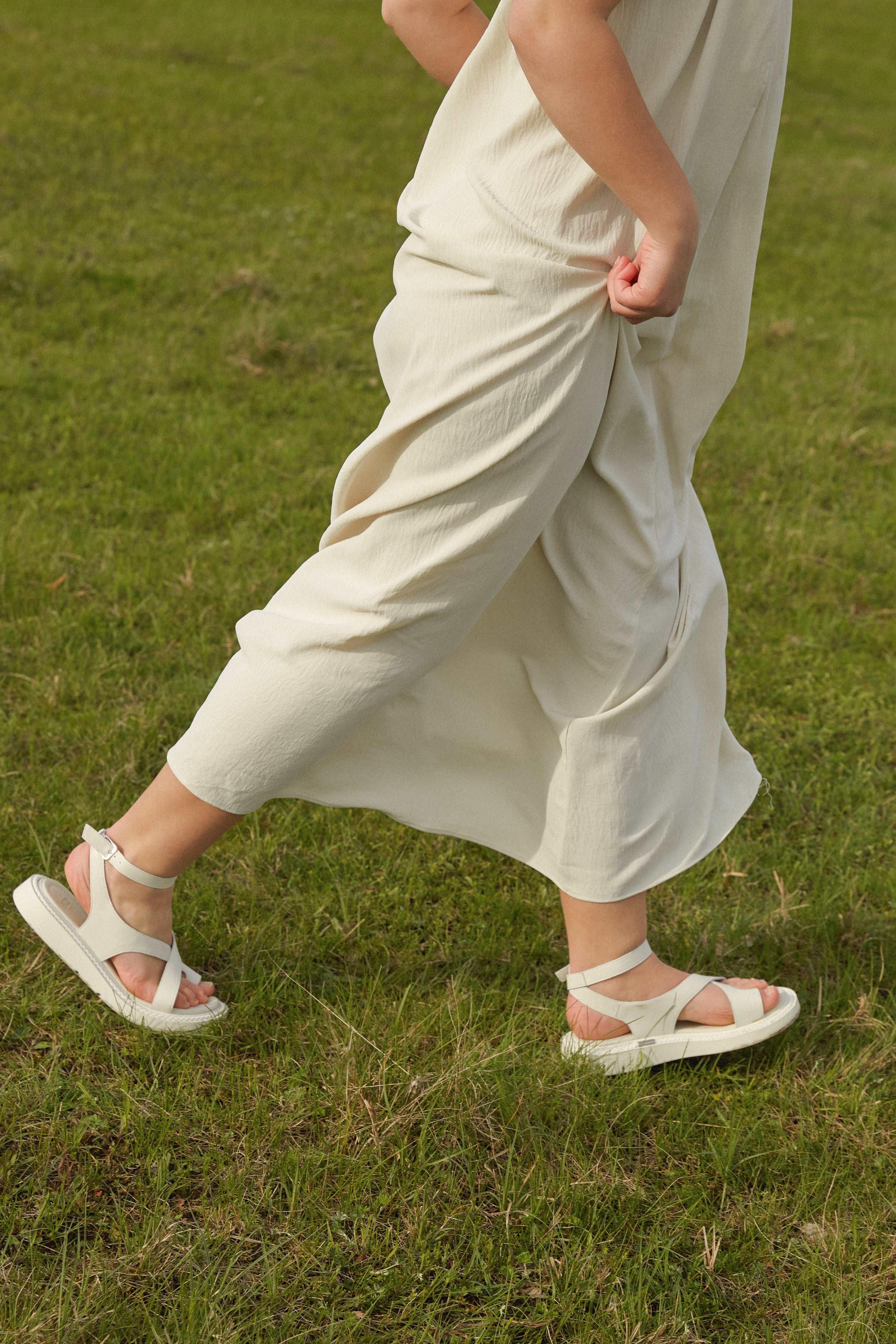Lifestyle-Ansicht der milchweißen Damen-Sandalen mit Plateausohle in Bewegung.