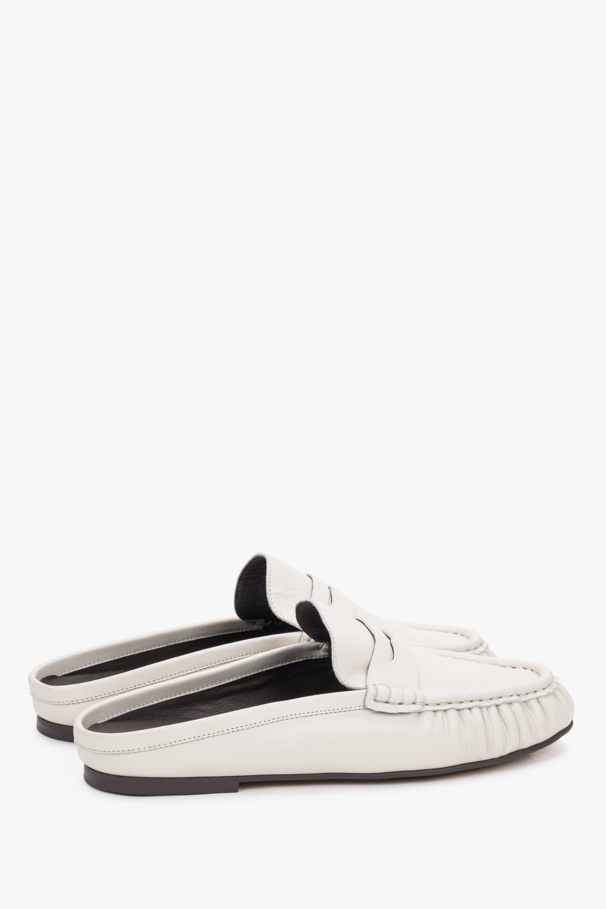 Milchweiße Damen-Mules aus Leder in schräger Seitenansicht mit Loafer-Detail