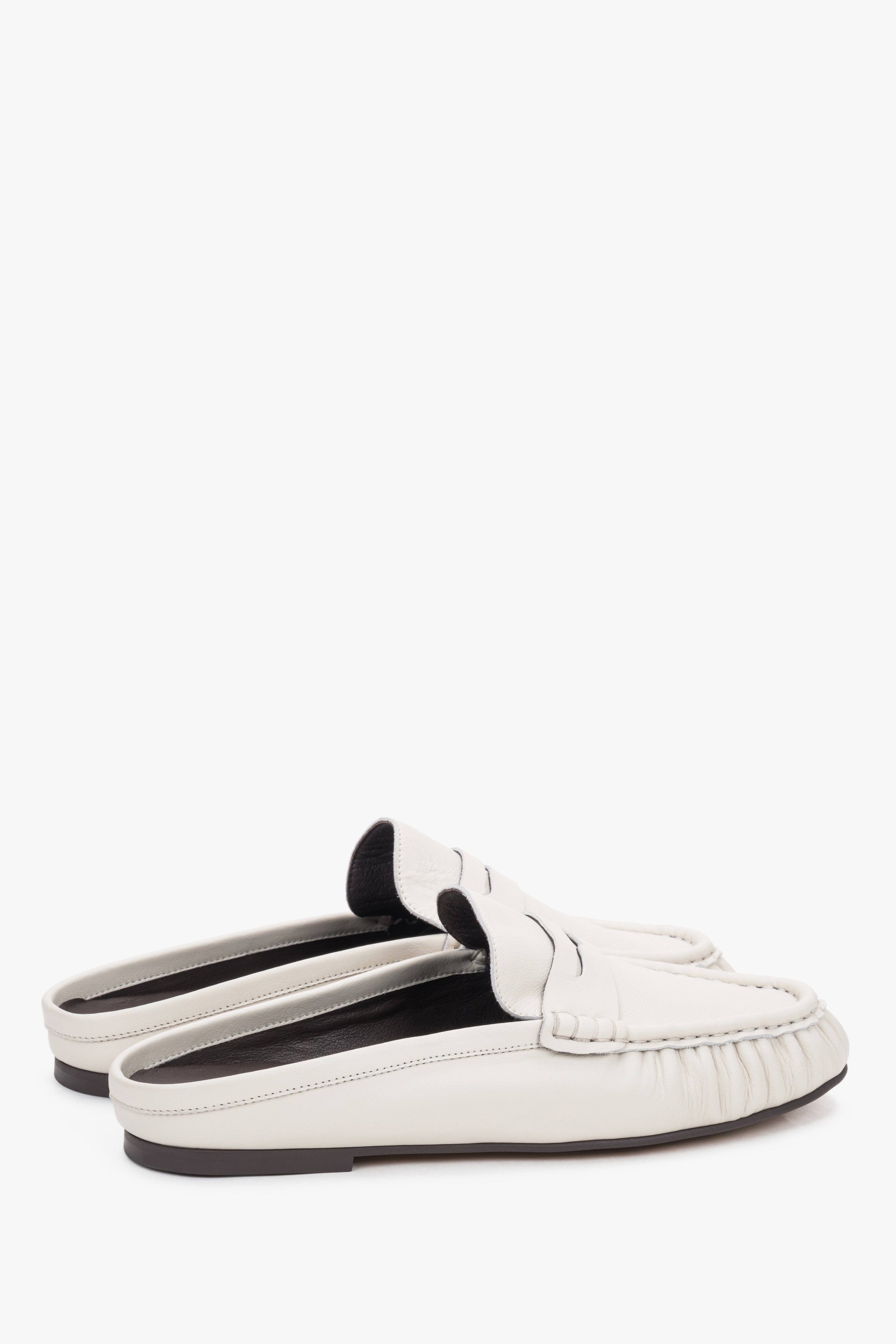 Milchweiße Damen-Mules aus Leder in schräger Seitenansicht mit Loafer-Detail