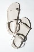 Draufsicht auf das Paar milchweißer Damen-Sandalen aus weichem Echtleder.