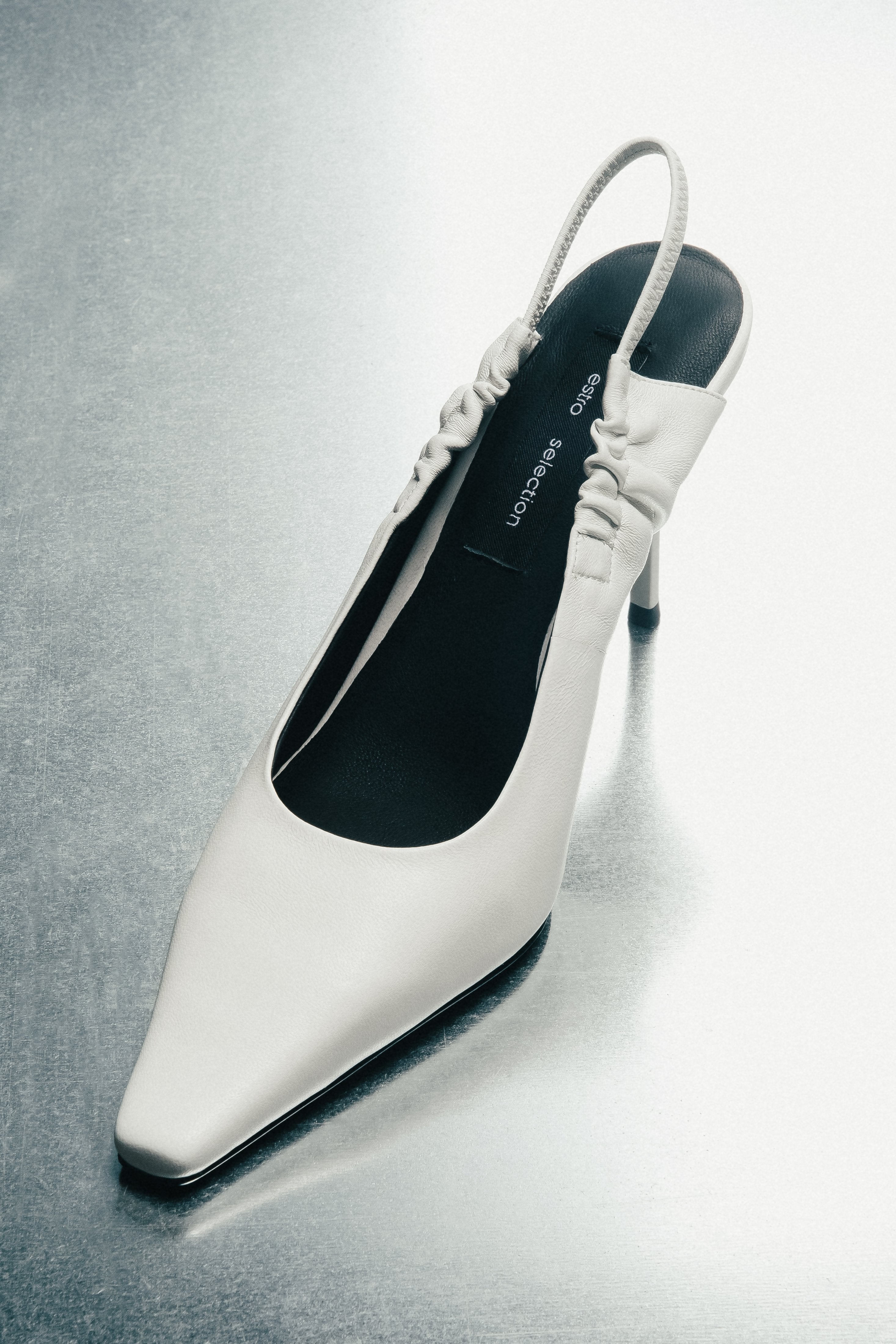 Schräge Ansicht der milchweißen Damen-Slingback-Pumps aus Echtleder.