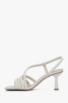 Linke Seitenansicht der eleganten milchweißen Riemchensandalette für Damen