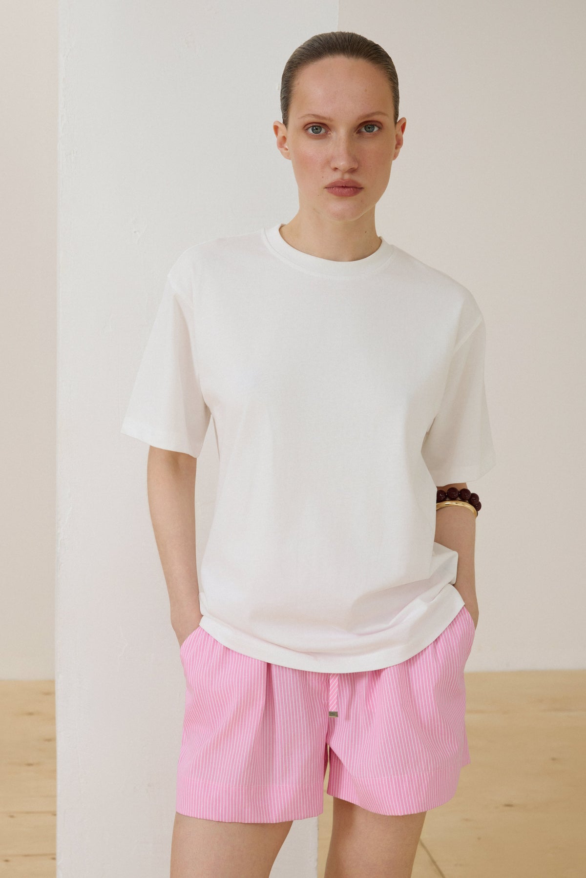 Model in weißem Damen-T-Shirt mit überschnittenen Schultern lässige Pose