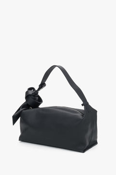 Perspektivische Seitenansicht der schwarzen Schultertasche zur Veranschaulichung der weichen Silhouette