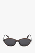 Frontale Ansicht der ovalen braunen Sonnenbrille mit transparentem Rahmen und dunklen Linsen