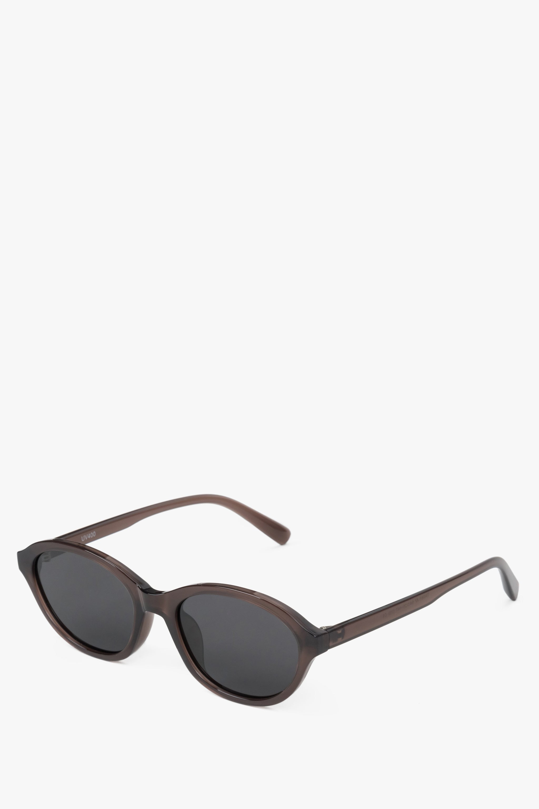 Schrägansicht der braunen Sonnenbrille, die die feinen Bügel und die sanfte Wölbung der Fassung zeigt 