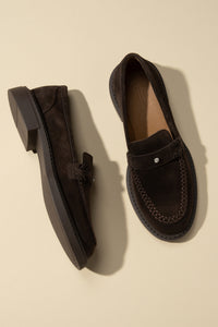 Draufsicht auf das Paar dunkelbrauner Penny-Loafer aus Velours in edlem Setting