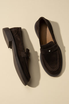 Draufsicht auf das Paar dunkelbrauner Penny-Loafer aus Velours in edlem Setting