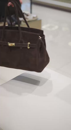 Präsentation der dunkelbraunen Velours-Henkeltasche in Bewegung