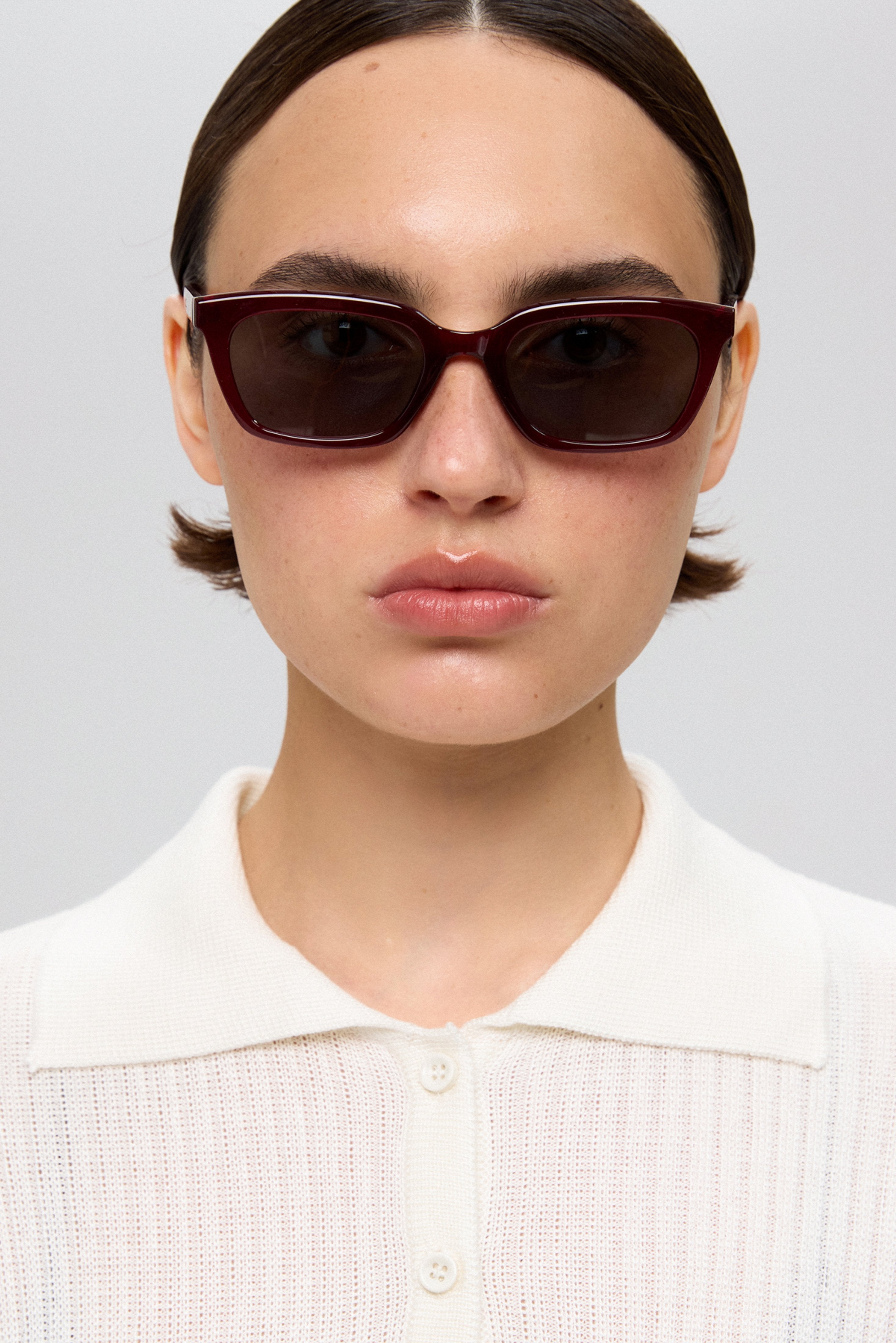Frontale Portraitaufnahme des Models mit der charakterstarken bordeauxroten Sonnenbrille 