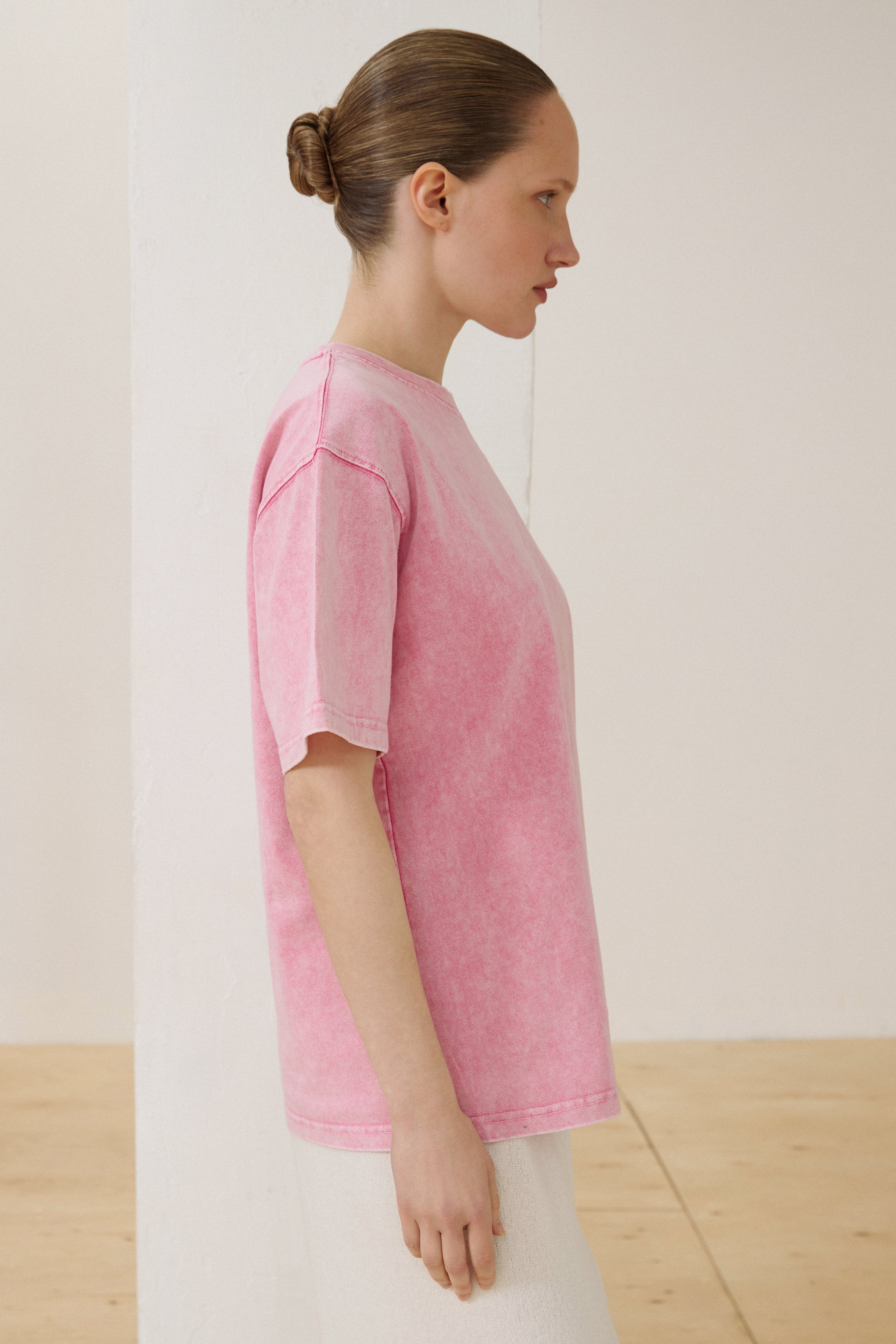 Seitenprofil des Models in rosa Boxy-T-Shirt aus Baumwolle
