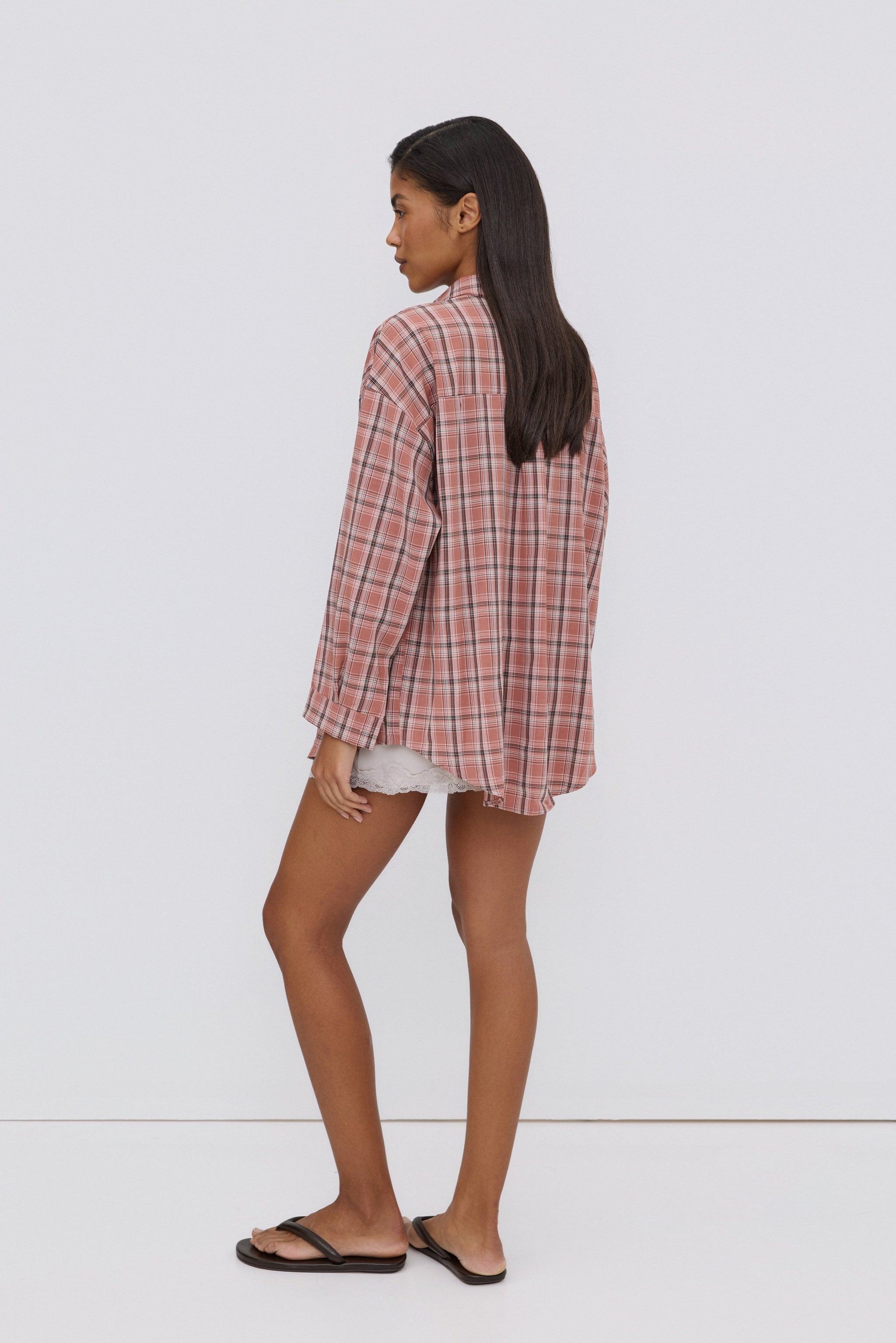 Rückansicht des Models in der überschnittenen, rosa karierten Oversize-Hemdbluse von Estro