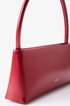 Perspektivische Seitenansicht der roten Baguette-Schultertasche zur Veranschaulichung der Tiefe