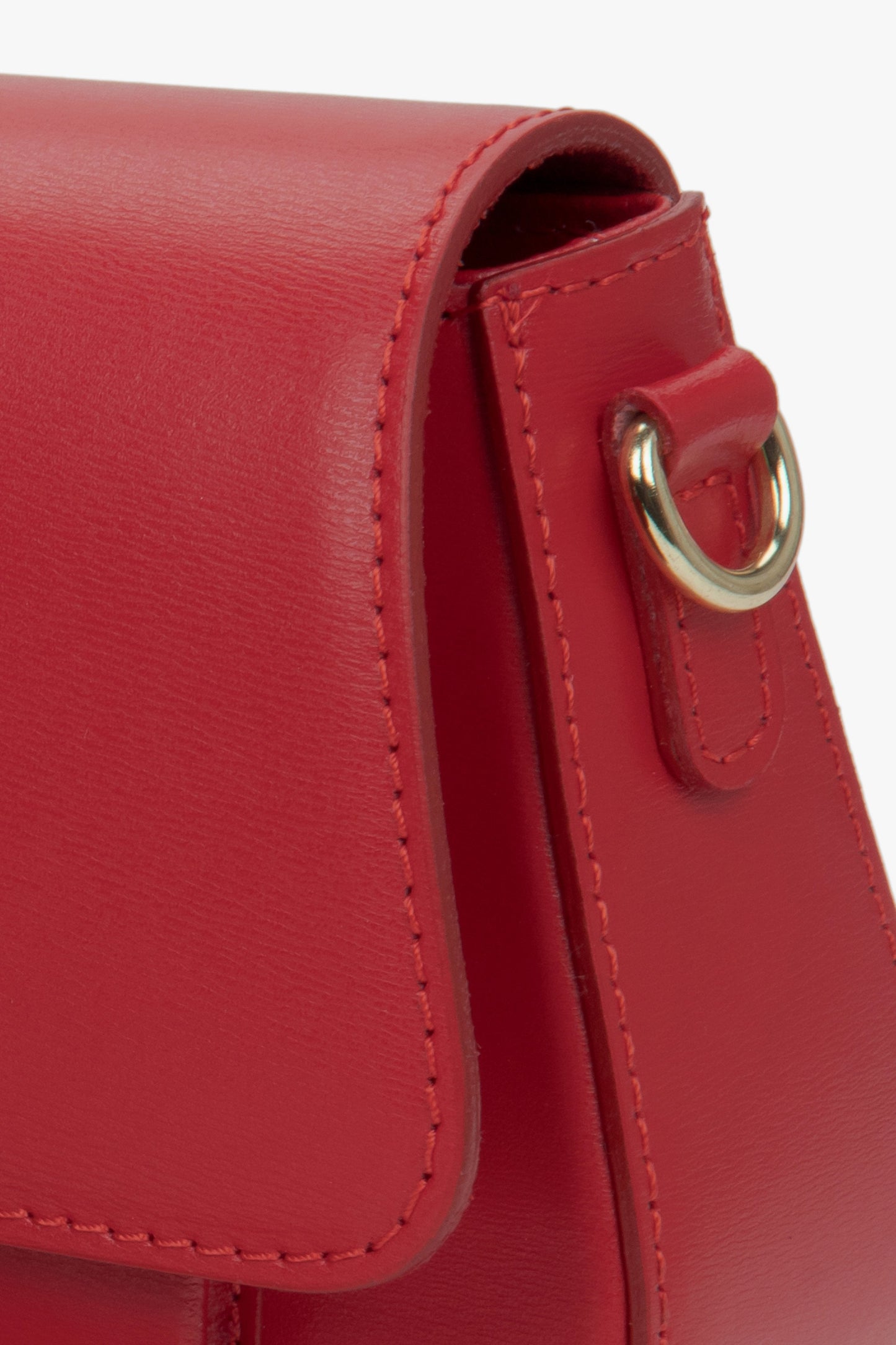 Nahaufnahme der seitlichen Partie der roten Leder-Schultertasche mit Fokus auf den goldenen Befestigungsring 