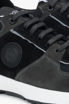 Detailansicht des schwarz-grauen Herren-Sneakers aus italienischem Veloursleder mit seitlichem Markenlogo und Schnürung