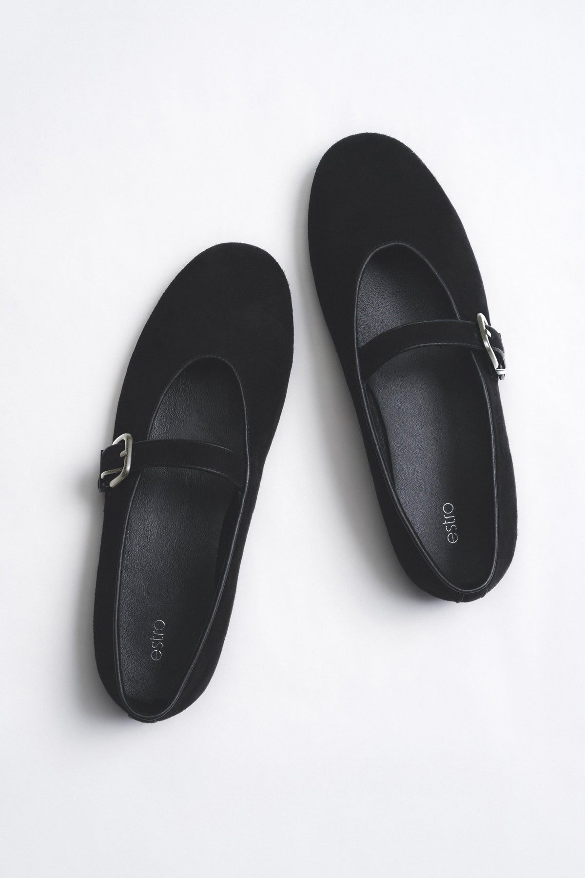 Draufsicht im stilvollen Arrangement des Paares schwarzer Riemchen-Ballerinas