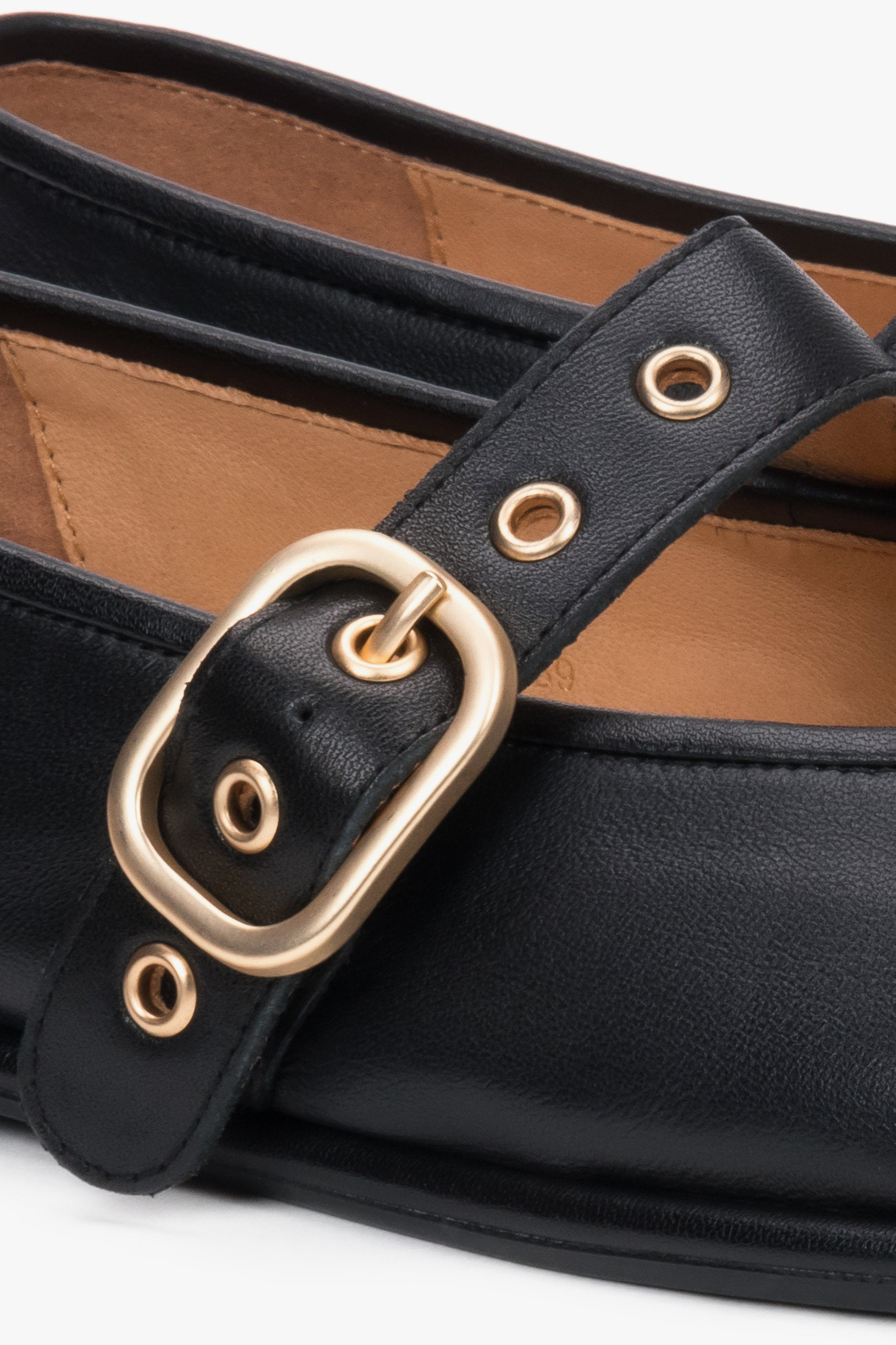 Detailaufnahme schwarzer Damen-Ballerinas aus Leder mit goldfarbener Schnalle