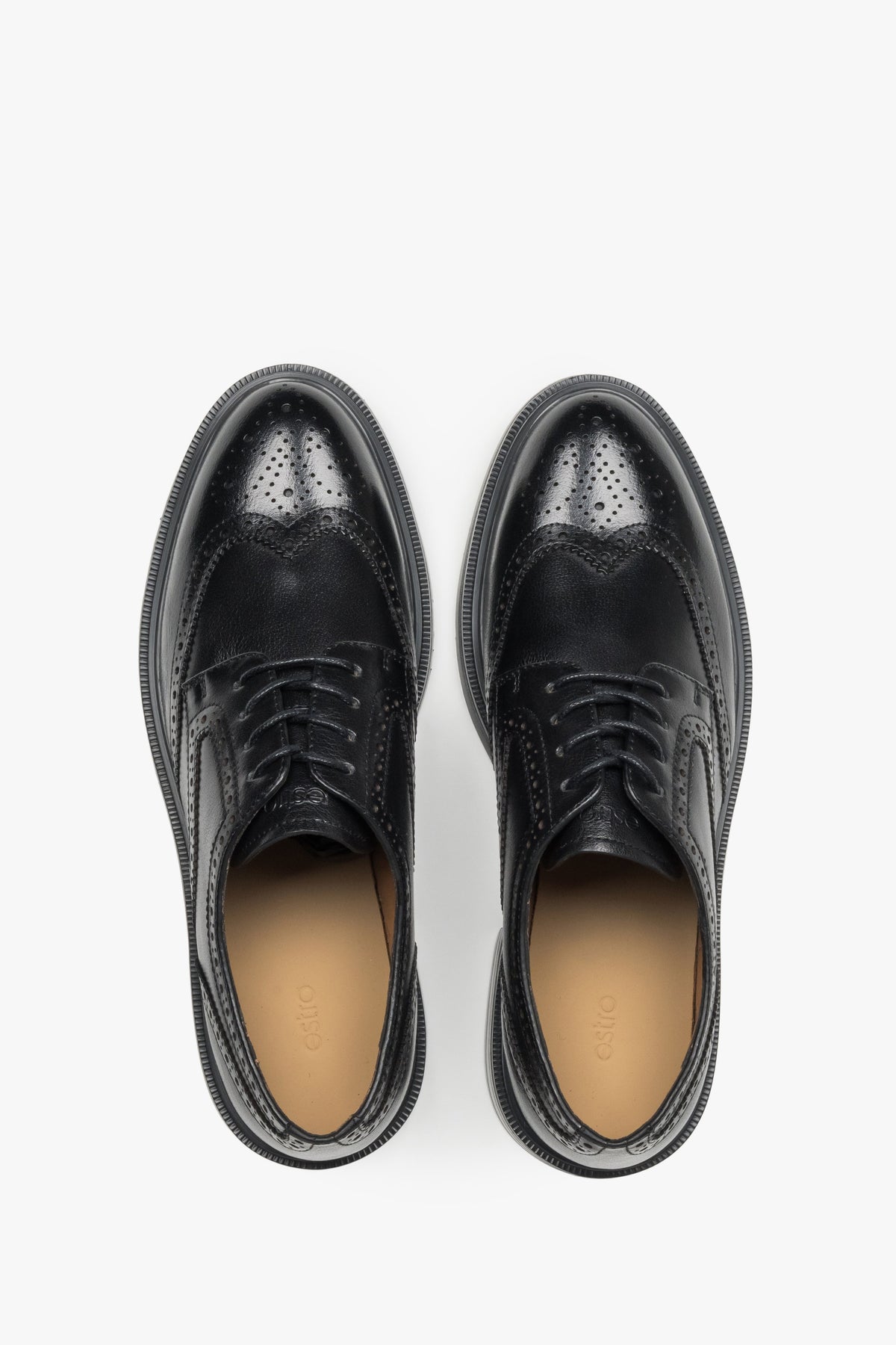 Symmetrische Draufsicht auf das Paar schwarzer Damen-Brogues mit hellem Lederfutter