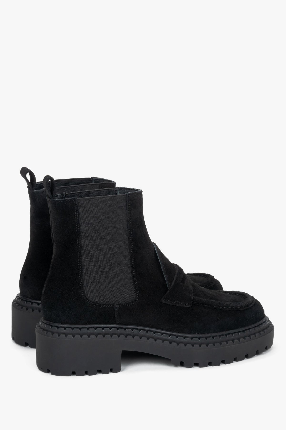 Diagonale Ansicht der schwarzen Damen-Chelsea-Boots aus Veloursleder von leicht hinten, die die Zuglaschen, den elastischen Schafteinsatz und das markante Sohlenprofil verdeutlicht.   