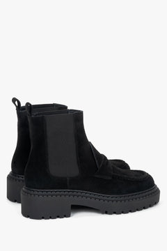 Diagonale Ansicht der schwarzen Damen-Chelsea-Boots aus Veloursleder von leicht hinten, die die Zuglaschen, den elastischen Schafteinsatz und das markante Sohlenprofil verdeutlicht.   