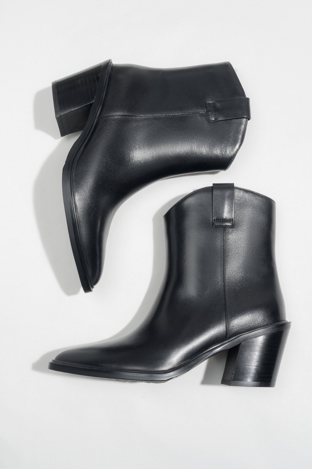 Flach liegendes Paar schwarzer Damen-Cowboystiefel aus Glattleder