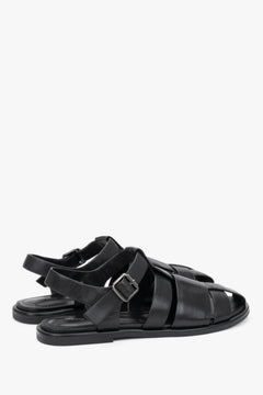 Rückansicht des Fersenbereichs der schwarzen Sandalen mit Fersenriemen.