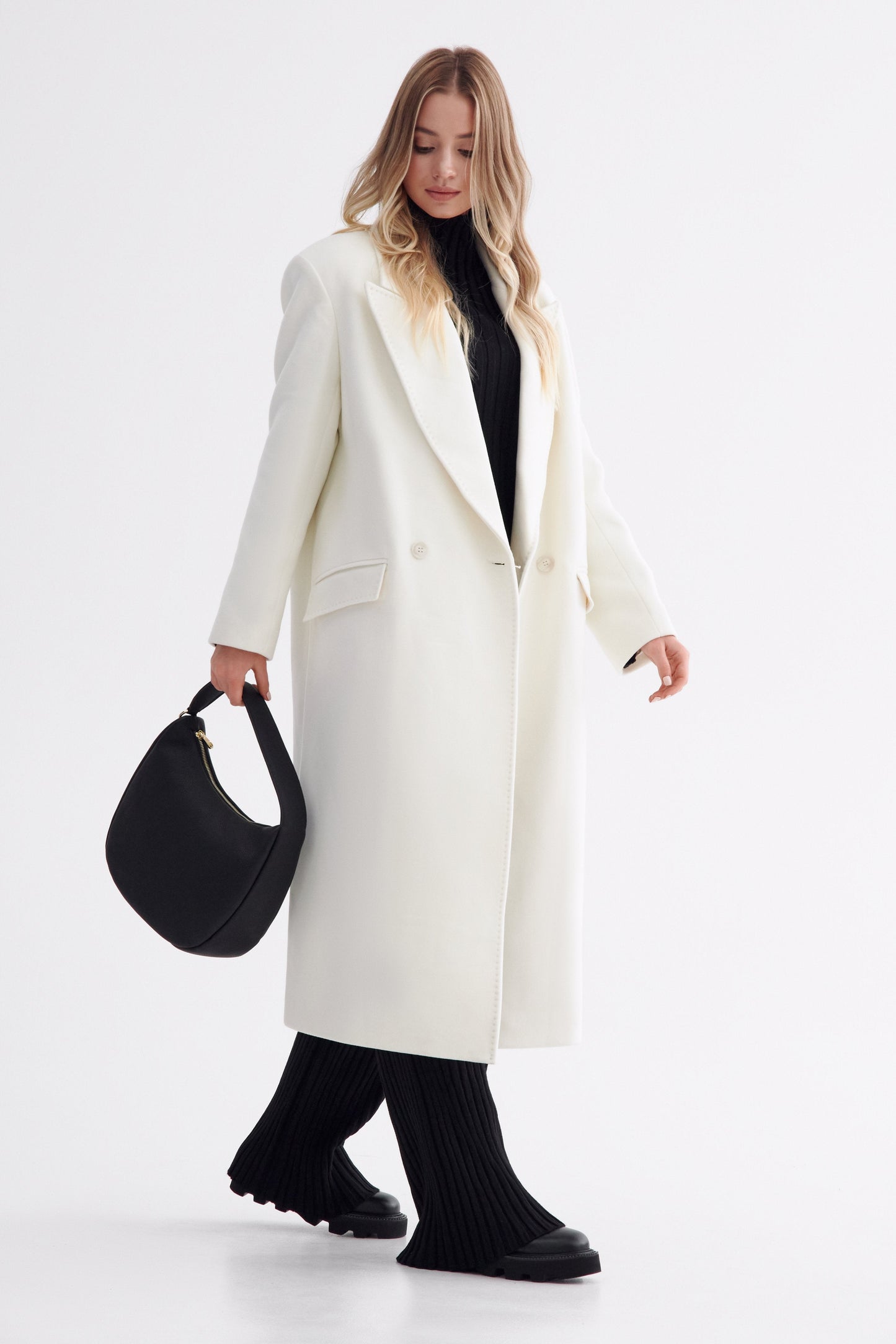 Schwarze Damen-Lederhandtasche in Halbmondform zum Tragen in der Hand – Modell im vollständigen Styling.