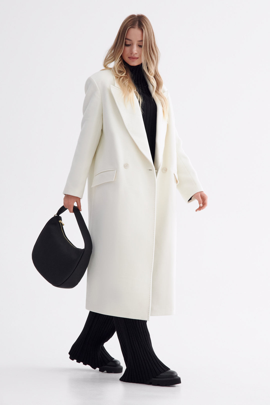 Schwarze Damen-Lederhandtasche in Halbmondform zum Tragen in der Hand – Modell im vollständigen Styling.