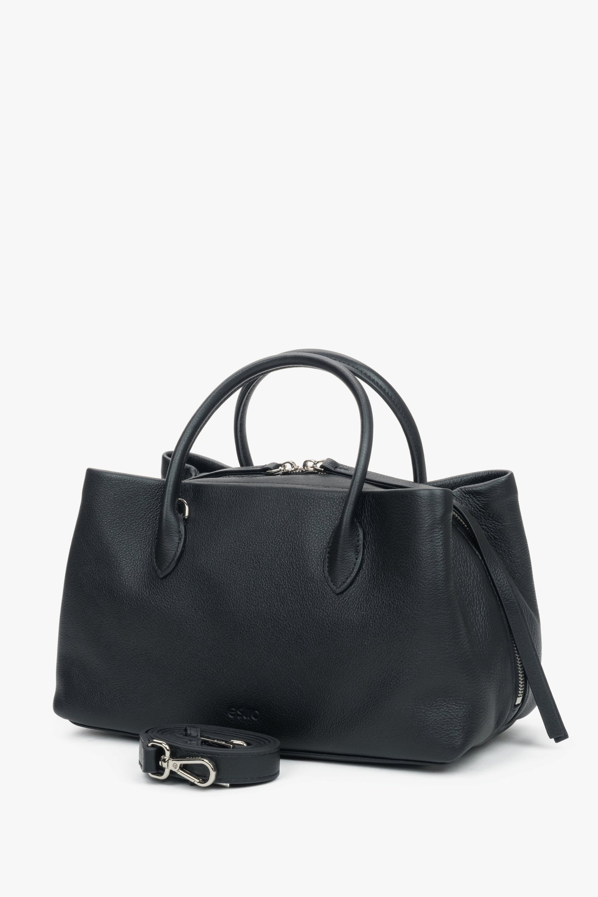 Schrägansicht der schwarzen Handtasche, die die geräumige Form und die silbernen Akzente hervorhebt 