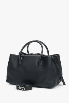 Schrägansicht der schwarzen Handtasche, die die geräumige Form und die silbernen Akzente hervorhebt 