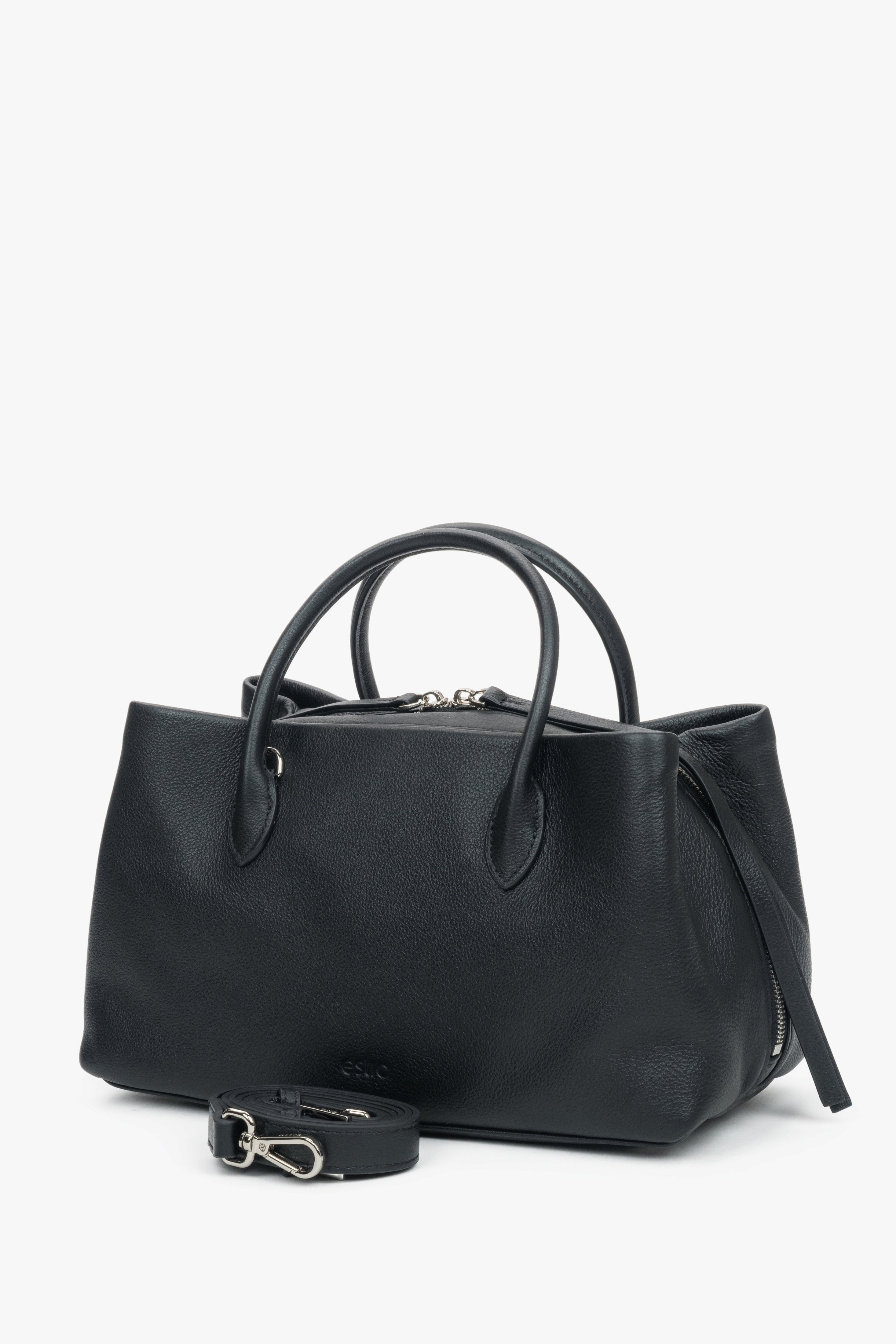 Schrägansicht der schwarzen Handtasche, die die geräumige Form und die silbernen Akzente hervorhebt 