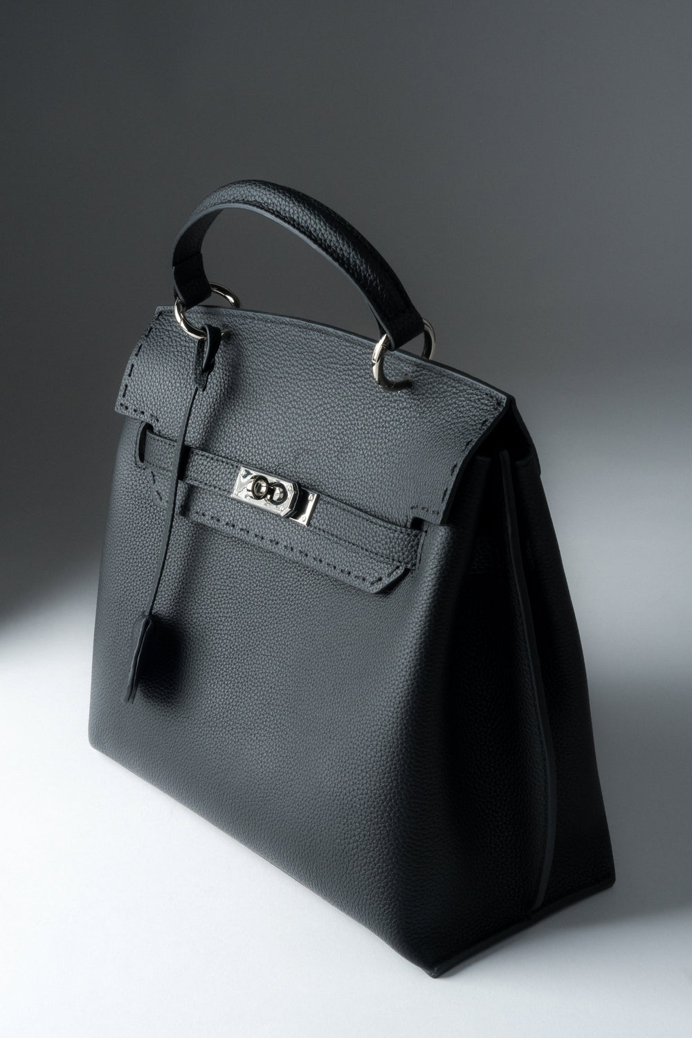 Schräge Frontansicht der schwarzen Damen Henkeltasche aus Naturleder mit silbernem Verschluss.