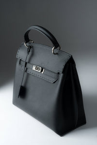 Schräge Frontansicht der schwarzen Damen Henkeltasche aus Naturleder mit silbernem Verschluss.